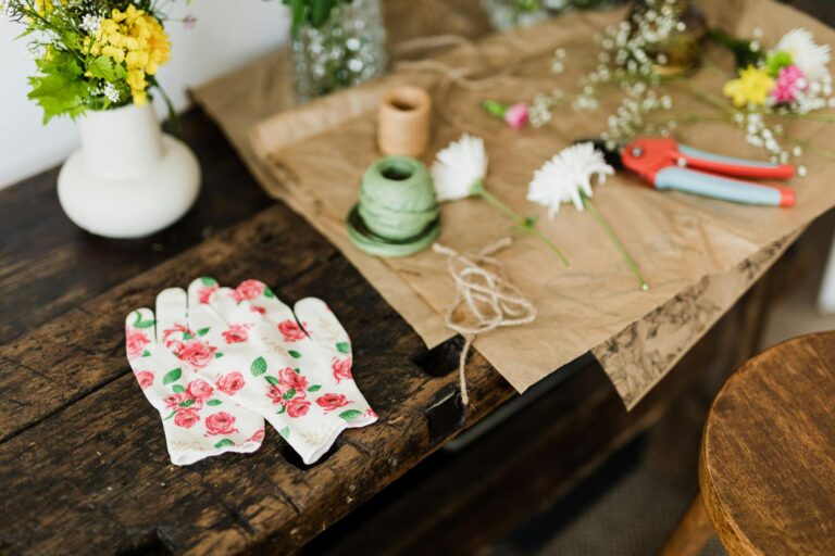 Artistic flat lay of floral arrangement tools and flowers on a rustic table, highlighting creativity in floristry.